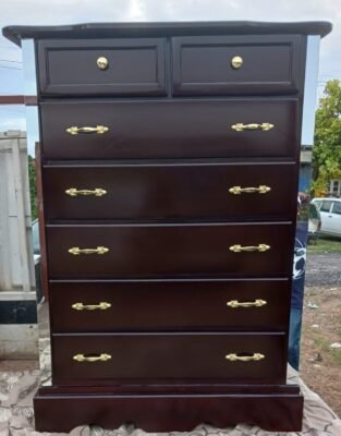 Brown color wooden dresser with a polished finish, featuring two small drawers on top and five larger drawers below, accented with gold handles.